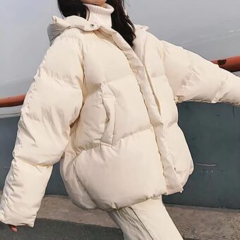 Femme brune portant la doudoune beige matelassée à capuche.