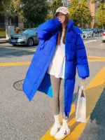 Photo d'une femme portant une doudoune longue bleu dans la rue