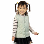 On voit une petite fille d'origine asiatique avec des couette qui porte une doudoune sans manche grise matelassée.