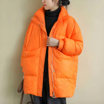 Femme portant une doudoune orange et tenant un sac à main