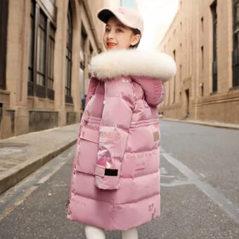 Fille dans une rue portant une casquette et une doudoune rembourrée rose pour enfant.