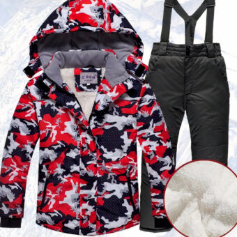 Ensemble doudoune de ski à capuche pour garçon rouge et pantalon noir devant un décor de montagne enneigée.