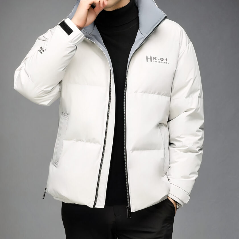 Photo d'un homme portant une doudoune blanche entre-ouverte dans un fond gris