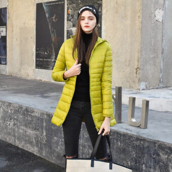 Femme dans la rue portant une doudoune jaune avec un bonnet et un sac à main beige