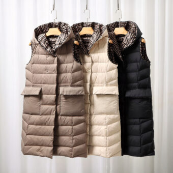 Doudounes longues fines sans manches marron, blanche et noir sur un portant.