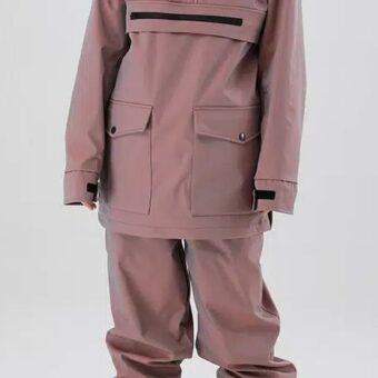 Adulte debout dont on ne voit que le corps, les bras le long du corps portant une doudoune rose et un pantalon assorti.