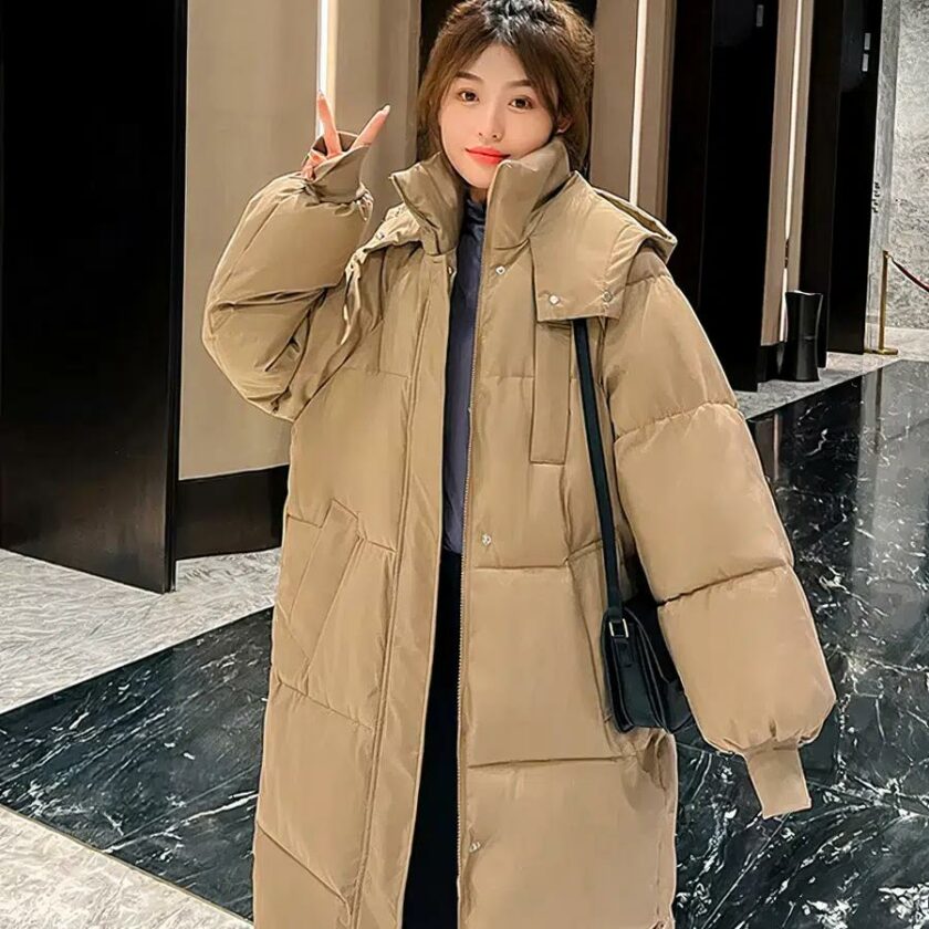 Photo d'une femme portant une longue doudoune camel dans un hall