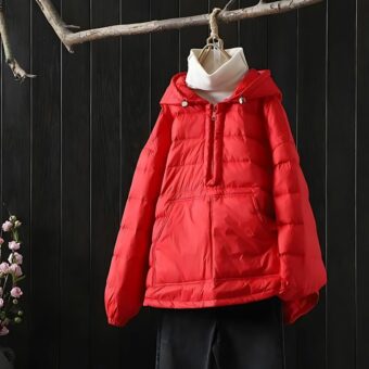 Doudoune rouge vif à enfiler pour femme, avec un col montant et une poche avant, suspendue sur un cintre en bois noir.