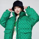 Une jeune femme porte une doudoune oversize extra chaude, col montant sans capuche en couleur vert vif.