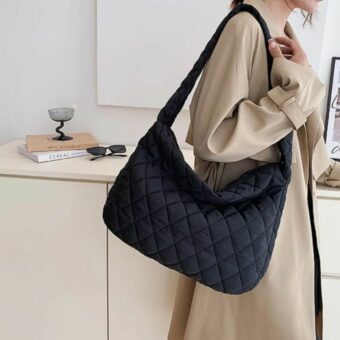 on voit une femme avec un manteau beige portant un sac à main doudoune pour femme il est noir